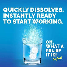 Effervescent tablets dropping into water with bubbling fizz in a glass