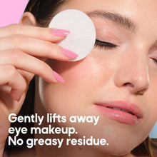 Micellar eye makeup remover pads held over closed eye, soft white round pad