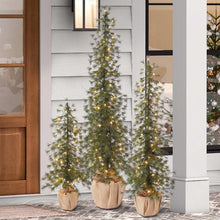 Artificial pine tree with warm LED lights, full branch silhouette in burlap pot