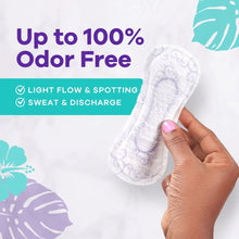 Hand holding a white panty liner with blue pattern, regular length