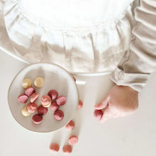Yogurt smoothie melt snack pieces in a small bowl with more pieces scattered