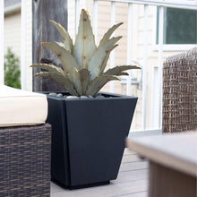 Metal agave sculpture with upright spiky pale gold leaves in a dark square planter