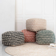 Woven wool pouf with striped weave in dark gray and cream.