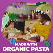 Organic pasta meal scene with a child and adult eating from bowls at a table
