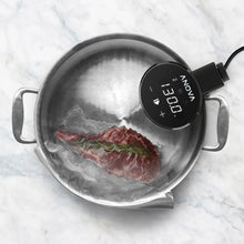 Sous vide cooker probe in stainless pot with lid, digital temperature shown on unit