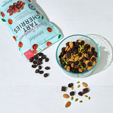 Dried tart cherries pouch next to a bowl of dark dried cherries with nuts