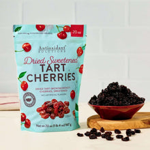 Dried tart cherries pouch beside a wooden bowl filled with dark dried cherries