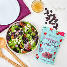 Dried tart cherries pouch next to a salad bowl with dried dark cherries