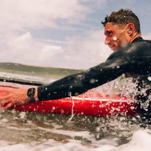 Smartwatch on swimmer’s wrist with black sport band during water splash