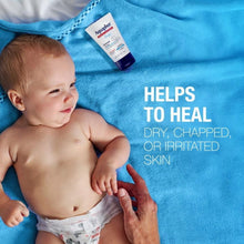 Baby on towel with healing ointment tube, helps heal dry, chapped skin