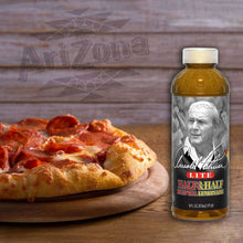 Half tea and half lemonade drink bottle beside sliced pizza