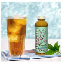 AriZona green tea bottle and iced tea glass with ice, on striped mat