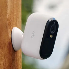 Wall-mounted white security camera with black lens housing and mounting bracket