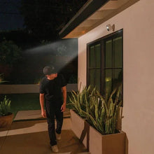 Outdoor security camera floodlight illuminating the front entrance at night