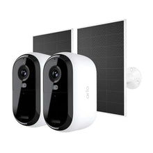 Two white security cameras with black lenses and solar panel backplates