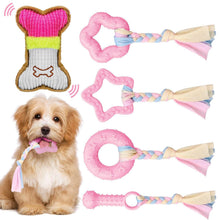 Pink plush squeaky dog chew toys set with braided tassels and bone, on display with puppy
