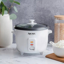 White Aroma rice cooker on countertop with black lid open
