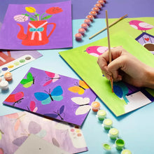 Paint-by-number art set canvas sheets with colored dot paints and a brush at work