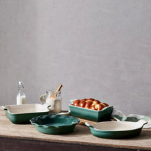 Four-piece stoneware bakeware set with green dishes and white interiors in various shapes