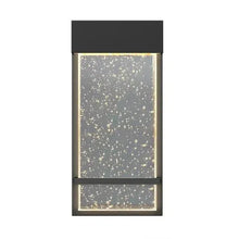 Black wall sconce with vertical speckled bubble-glass shade and metal bar