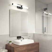 Wall-mounted vanity light above mirror with frosted tube and dark backplate