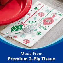 Folded holiday paper napkins with red and green ornaments and snowflakes on a white sheet