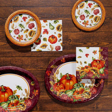 Harvest paper plates and folded napkins set displayed on a wooden surface