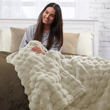 Faux fur throw blanket, light beige, plush curly texture draped over bed