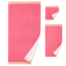 Coral towel set with striped trim, folded and flat for display