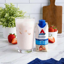 Strawberry protein-rich shake carton beside a glass of pink shake