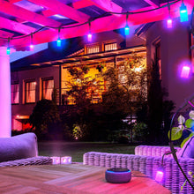 Outdoor string lights overhead with multicolor frosted bulbs glowing along the line