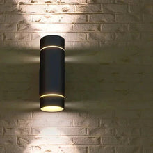 Black cylindrical outdoor wall sconce with warm white light