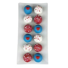 Assorted cake balls on a white tray, red, white, and blue with heart and speckles.