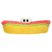 Plush hot dog toy with smiling eyes topper, yellow bun with red and green accents