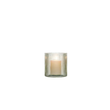 Green ribbed glass hurricane candle holder with lit candle inside, ribbed cylinder