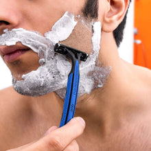 Man shaving with a blue-handled disposable two-blade razor