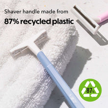 Disposable razor with two blades and blue handle on a towel.
