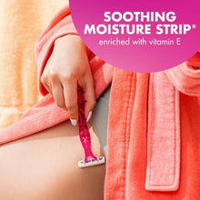 Disposable women’s razor with pink handle and three blades near skin