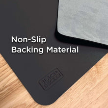 Black faux leather desk mat close-up with textured grip backing on the corner
