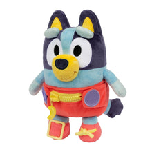 Plush baby Bluey dress toy standing, dark navy head, light blue shirt, red overalls with toys