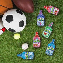 Assorted baby bottle pop candies in colored bottles on green grass, with 6 pieces