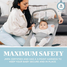 Gray portable baby bouncer with infant in seat next to caregiver on sofa