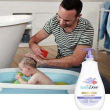 Baby Dove body wash bottle on counter beside father washing baby in a bathtub