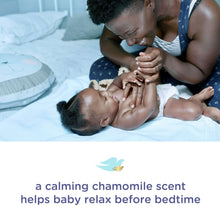 Baby Dove body wash use scene with parents gently washing baby in bed