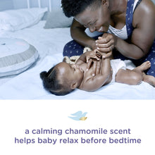 Caregiver gently applying lotion to baby’s skin in a bedtime setting