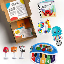 Baby music toy set with blue whale character, mini piano, and animal toy figures