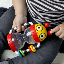 Baby activity rattle with clear tube and red base, held between both hands