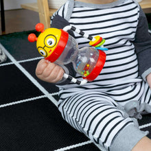 Baby activity rattle with red head and clear shaker tube held in one hand