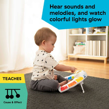 Baby Einstein light bar activity station in baby’s hands on carpeted floor