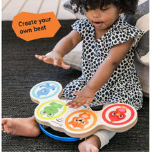 Wooden touch drum toy with four animal face buttons, held by baby